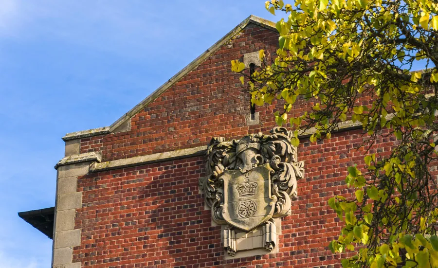 An old stone version of the University of Southampton coat of arms, affixed to the side of Hartley Library.