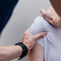 Unsplash image of a physiotherapist manipulating a patient's shoulder muscles