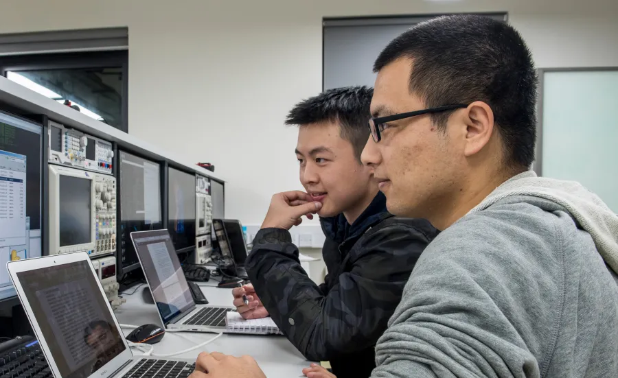 Two male computer science students sitting and looking into their computer