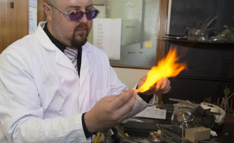A glass expert uses scientific glassblowing equipment