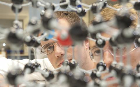 Scientists using a molecule model