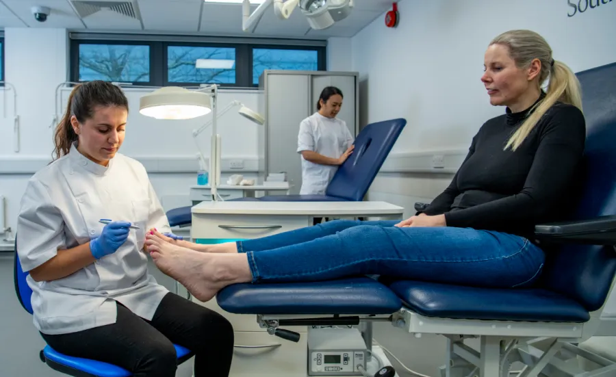 Podiatry student practising clinical skills with a client