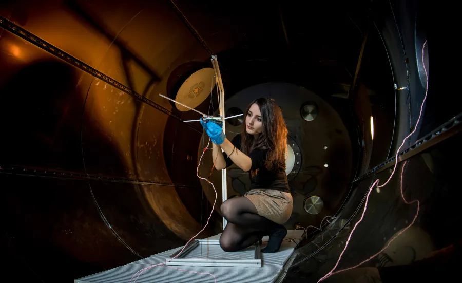 A student checks their experiment in the electric propulsion lab