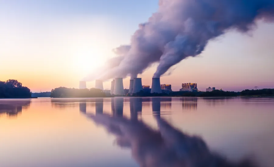 A landscape image of a coal-fired power station expelling pollution into the sky.