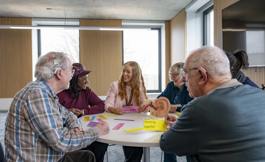 Kate discussing hearing loss and brain health with a group of older people 
