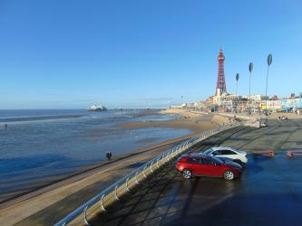View of Blackpool Tower, beach and coastal defences on a sunny day.