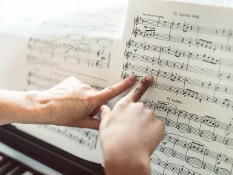 2 fingers pointing at sheet music on a piano