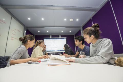 Group of students at work around a table in the maths student centre.