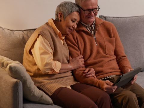 Pexels image of an older couple on a couch viewing a tablet screen