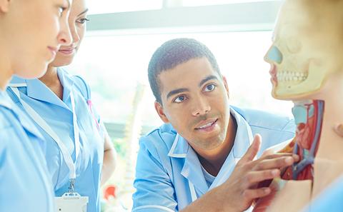 Male nurse learning anatomy in classroom