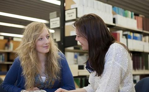 Two students smiling at each other