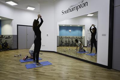 People stretching in front of mirror