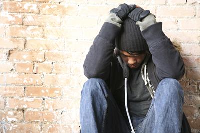 Young man sitting next to the wall