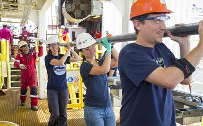 Lisa McNeill carries a core during an IODP expedition.