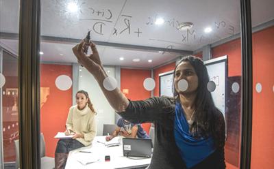 Students writing formula on glass