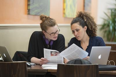 Two students having a discussion at a desk