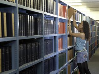 A student getting a book from the shelves