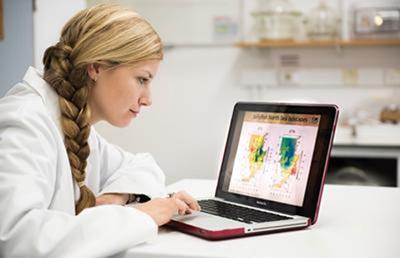 Dr Katie St John Glew on a laptop