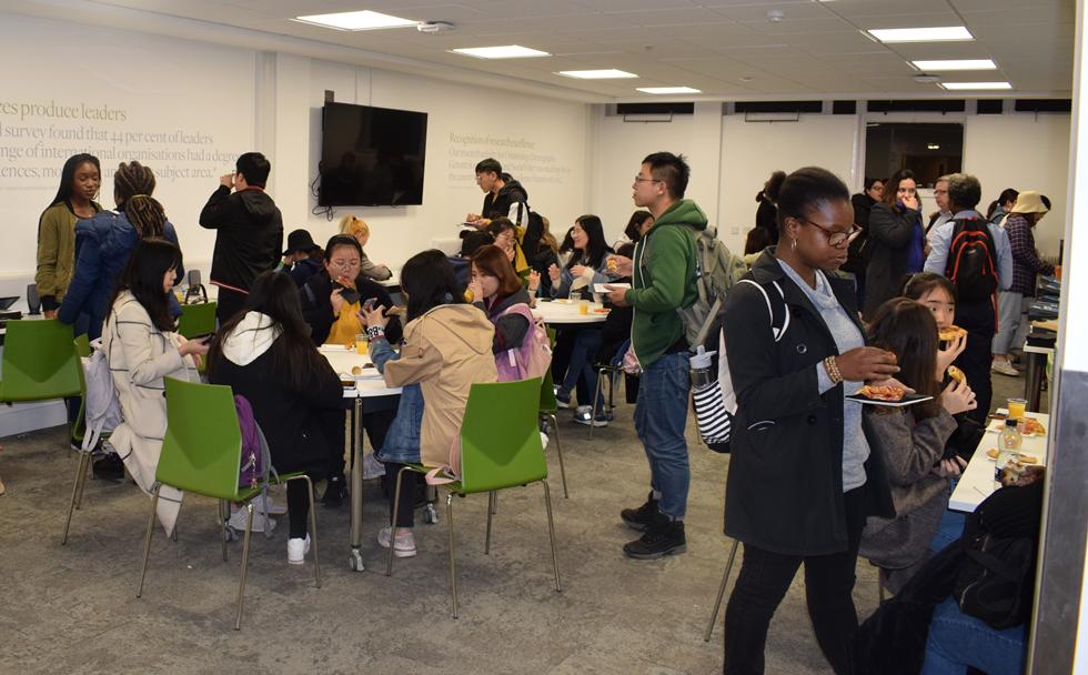 Students mingling with staff and enjoying delicious pizza!