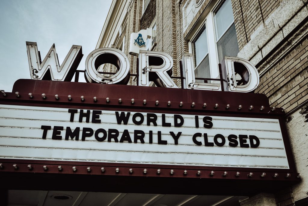 The image shows a cinema sign saying that the world is temporarily closed 