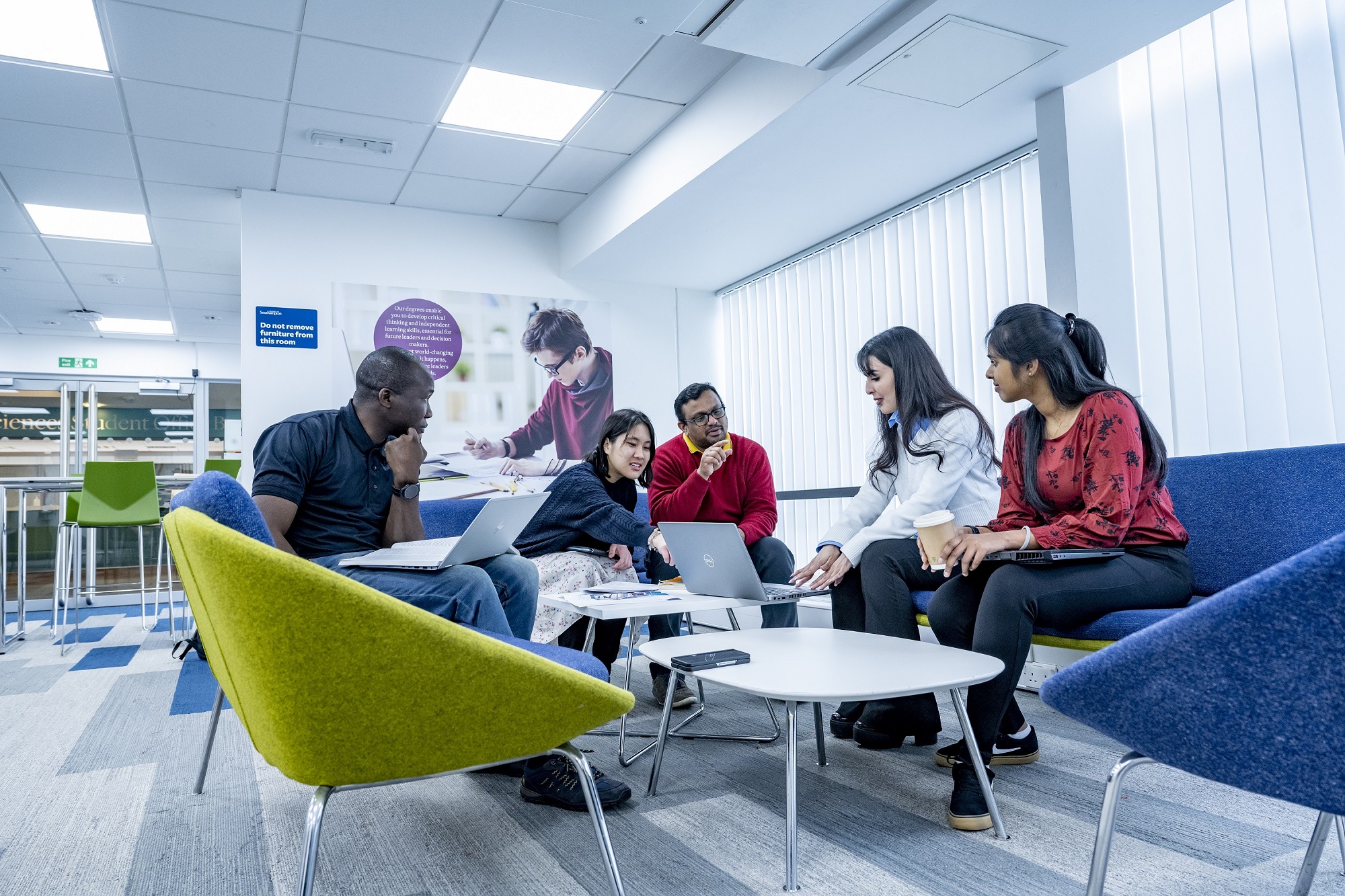 Students preparing group assigment in a room in campus