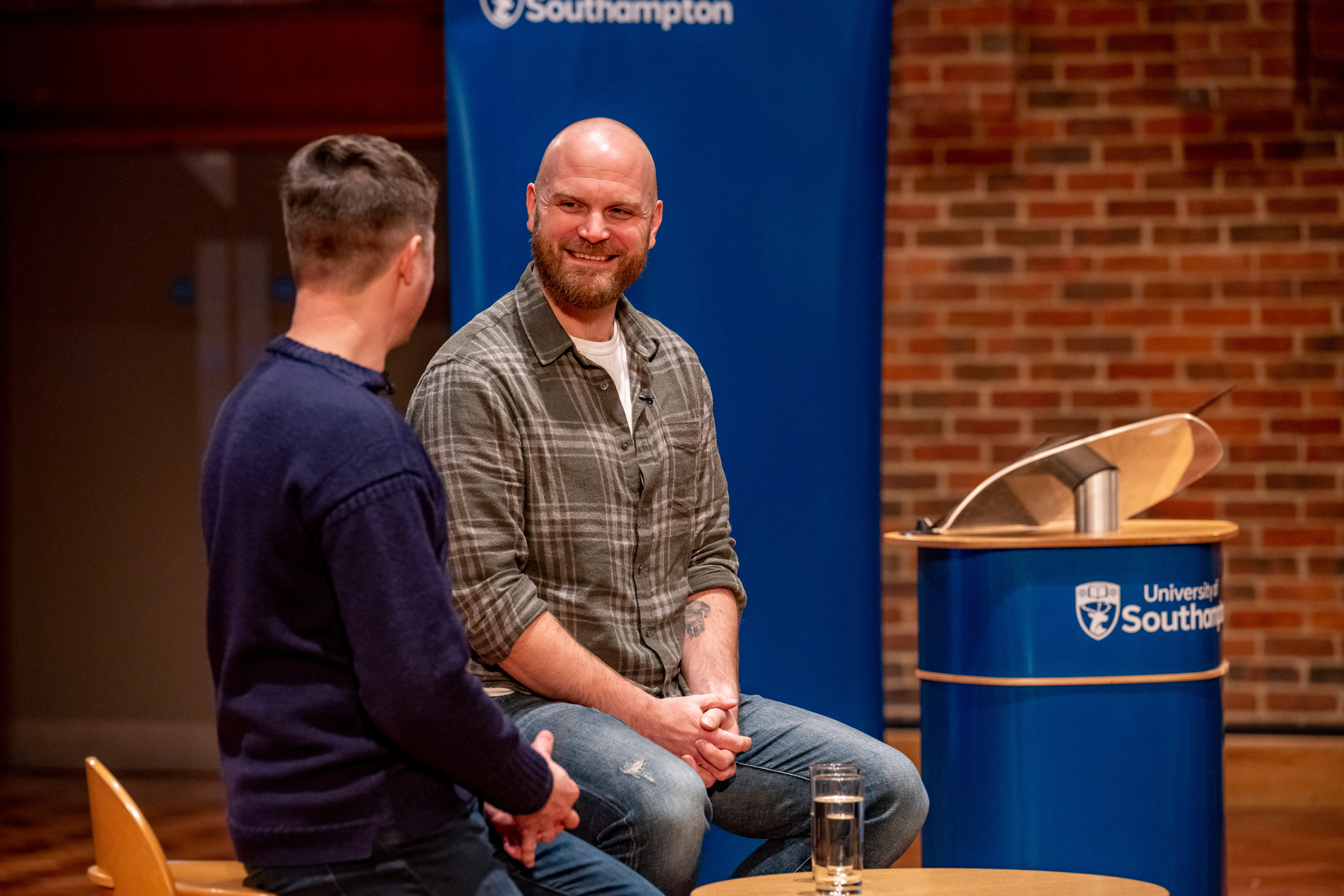 Will smiling at Dan as they're sat on stage