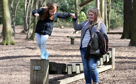 Mother and daughter playing in wood
