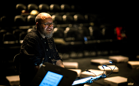 Man sat at front of dark theatre