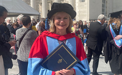 Smiling woman in cap and gown