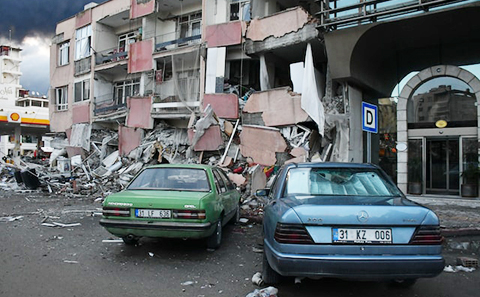 Two cars by a damaged building