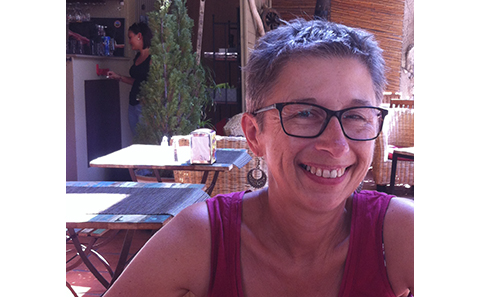 Woman with short hair, in red vest top and glasses