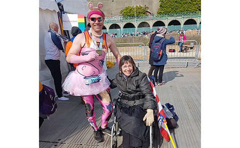 Man stood with woman in wheelchair