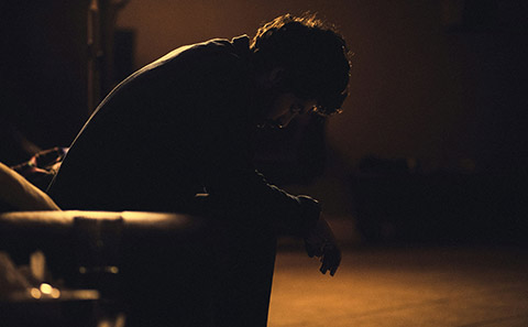 Man slumped in chair looking sad.