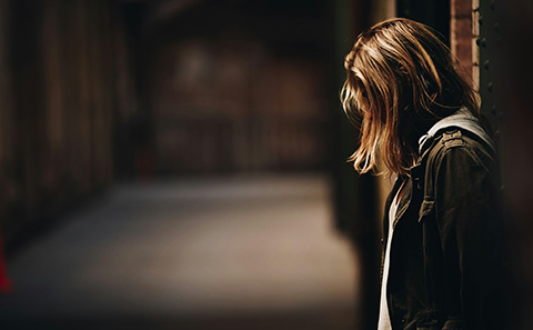 Woman stood against a wall
