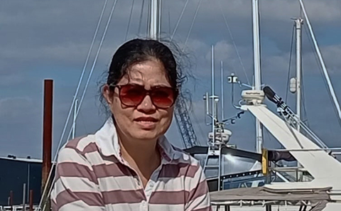 Woman in sunglasses, boats behind