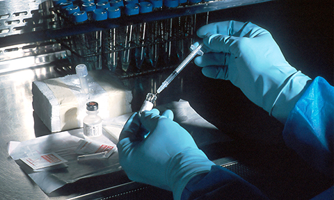 Scientist holding vial and syringe