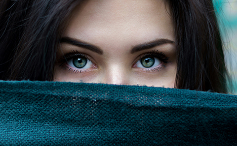 Woman's eyes peer from behind scarf