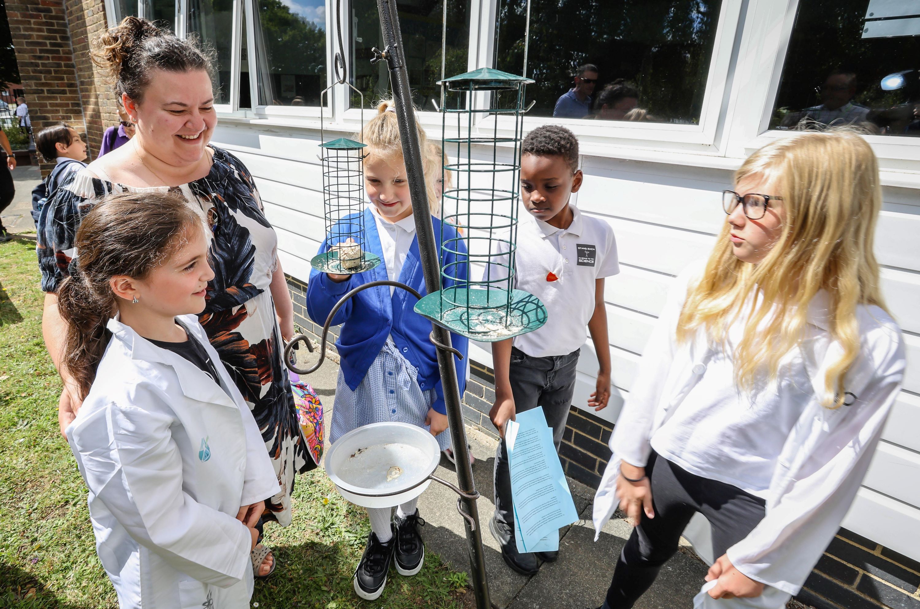 Children and teacher looking at bird feeding station