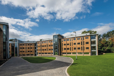 Chamberlain halls at the Glen Eyre complex with a lawn in front and slightly clouded skies above.