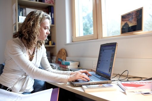 A student using their laptop in their halls bedroom