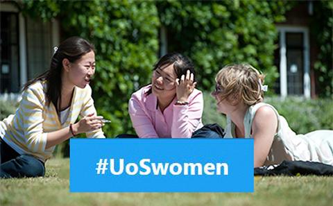 Women sitting on the lawn on campus