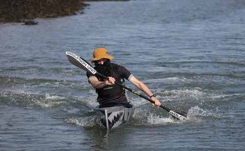 Wolfson Unit engineer Magnus Gregory paddles to victory in the Seawork Cardboard Boat regatta (Photo: Seawork)