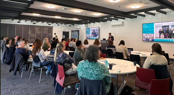 Group of people watching a presentation at a Southampton Geospatial event
