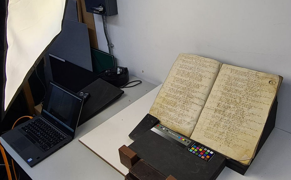 Historic handwritten document on a stand being lit by a diffused lamp