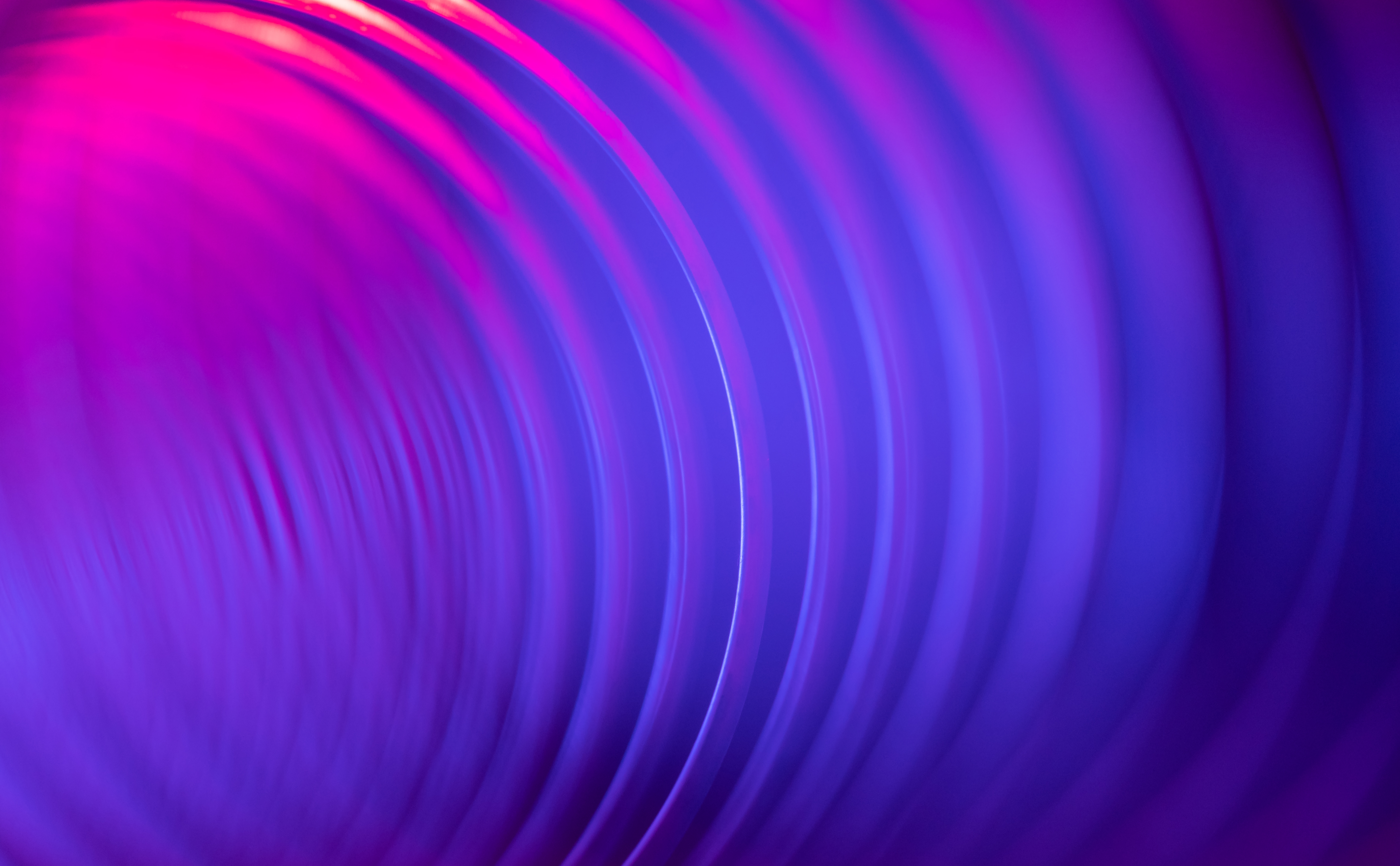 Abstract images of rippled waves fading from pink to purple colour.
