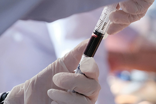 Gloved handed holding a blood sample
