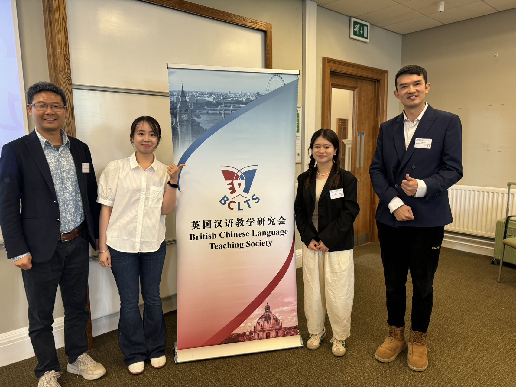 British Chinese language teachers standing with the conference information flag