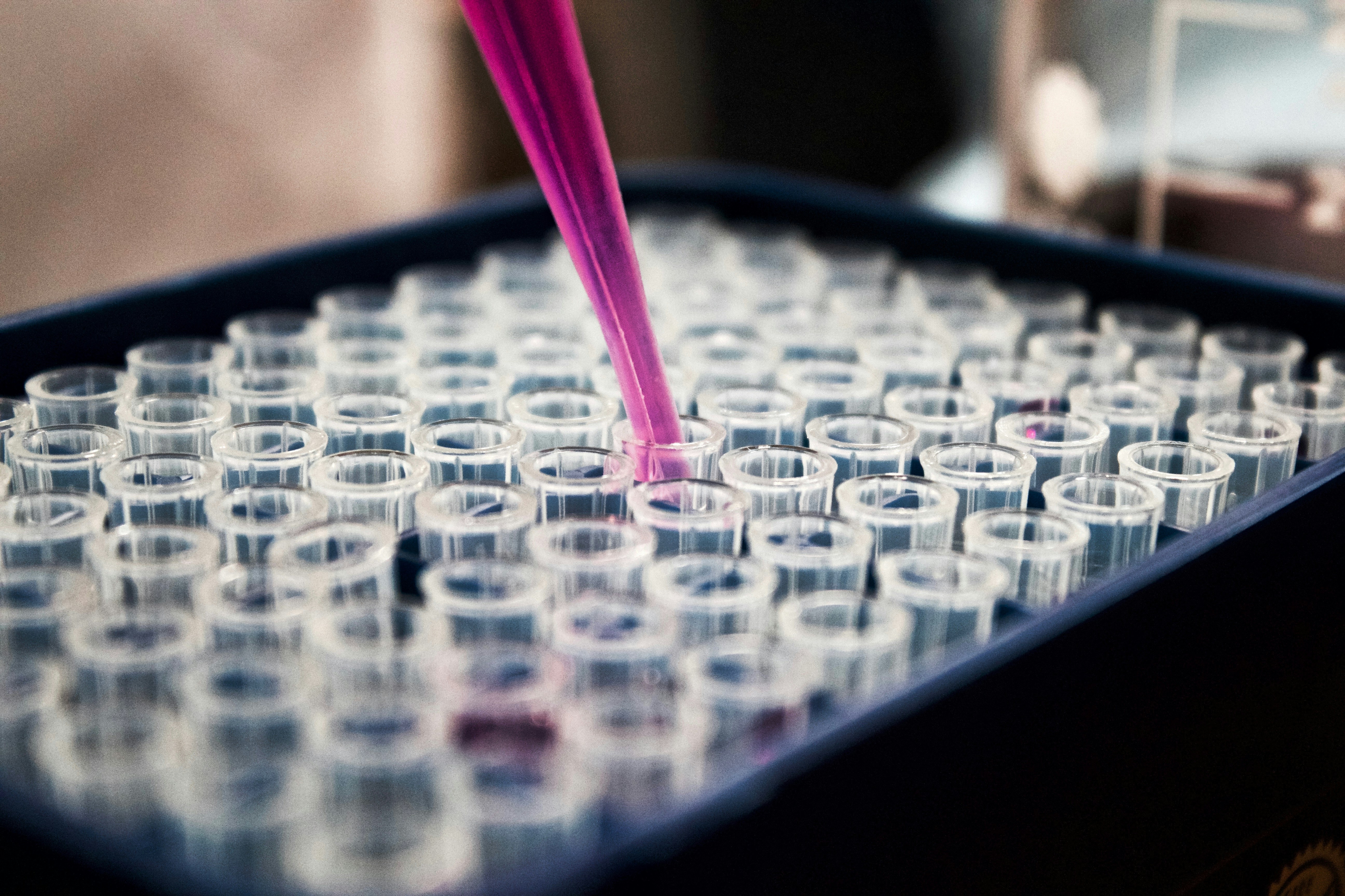 Vial with pink liquid hovering over test tube