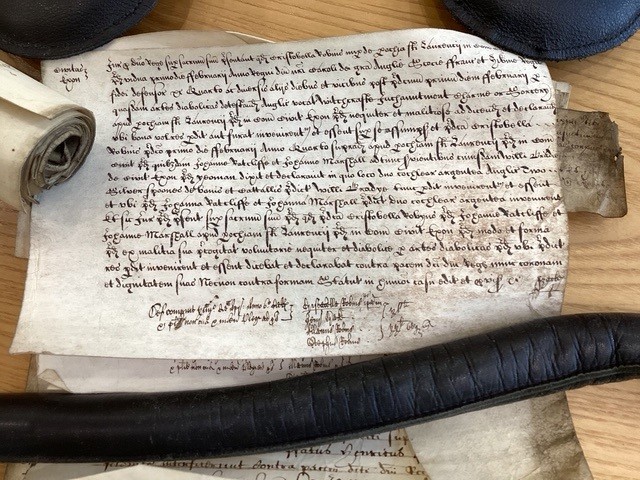 A parchment scroll court document written in old English.