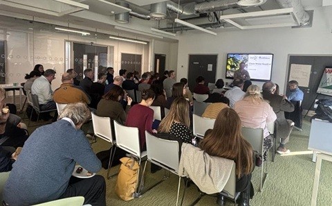 People seated in a conference room watching a presentation.